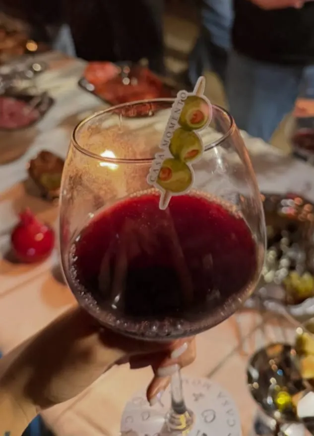 Copa de vino tinto con aceitunas en un palillo de Casa Momento